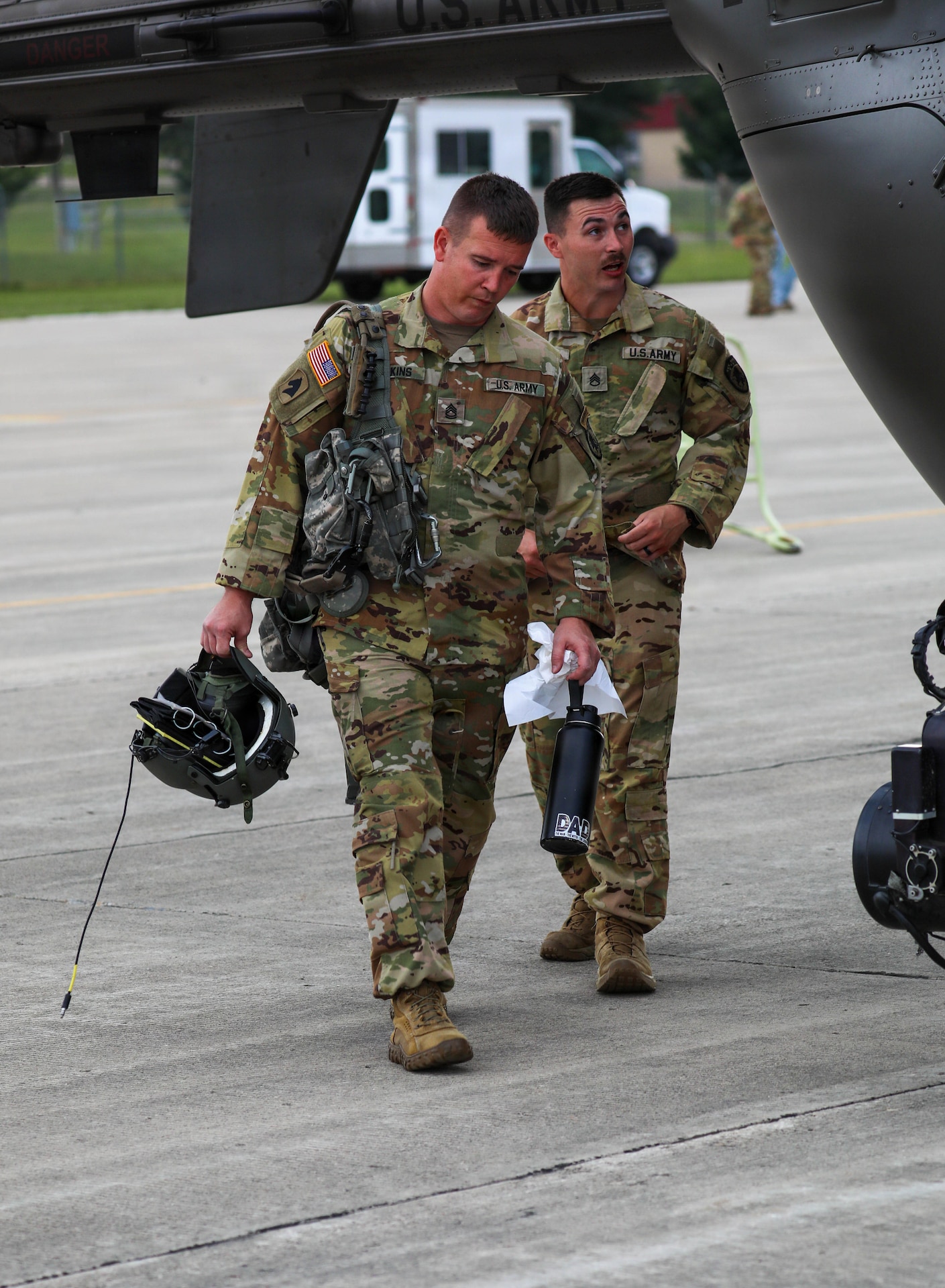 U.S. Army Sgt. 1st Class Shawn Firkins and Staff Sgt. Christopher Poole, crew chiefs with Charlie Company, 1st Battalion, 376th Aviation Regiment, Kentucky National Guard, head out to the aircraft prior to their simulated surveillance mission at Volk Field Combat Readiness Training Center (CRTC), Wisconsin, during Patriot 26, Aug. 25, 2026.