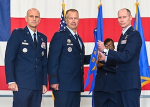 U.S. Air Force Maj. Gen. Ty Neuman, Eighth Air Force and Joint-Global Strike Operations Center commander, center, Col. Erick Lord, 28th Bomb Wing commander, left, and Lt. Col. Joshua Dawkins, B-21 Integration Detachment 1 commander, pose for a photo