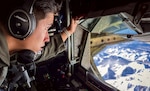 U.S. Air Force Airman 1st Class Joseph Saldana, a boom operator assigned to 50th Air Refueling Squadron, observes the Alaskan landscape during a refueling mission at Northern Edge 23-1 at Joint Base Elmendorf-Richardson, Alaska.