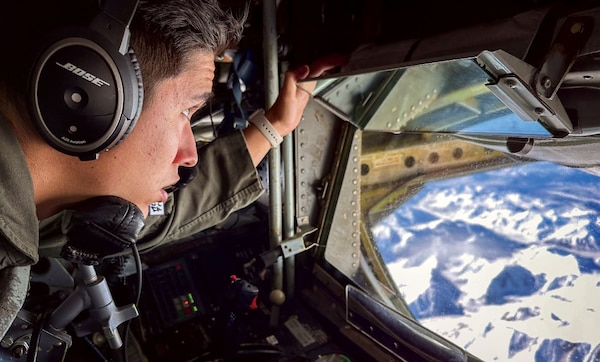 U.S. Air Force Airman 1st Class Joseph Saldana, a boom operator assigned to 50th Air Refueling Squadron, observes the Alaskan landscape during a refueling mission at Northern Edge 23-1 at Joint Base Elmendorf-Richardson, Alaska, May 18, 2023. Northern Edge provides a large-scale opportunity to enhance inter-service capabilities focused on joint combat operations in the Indo-Pacific region. (U.S. Navy Photo by Mass Communication Specialist 1st Class Jen S. Martinez)