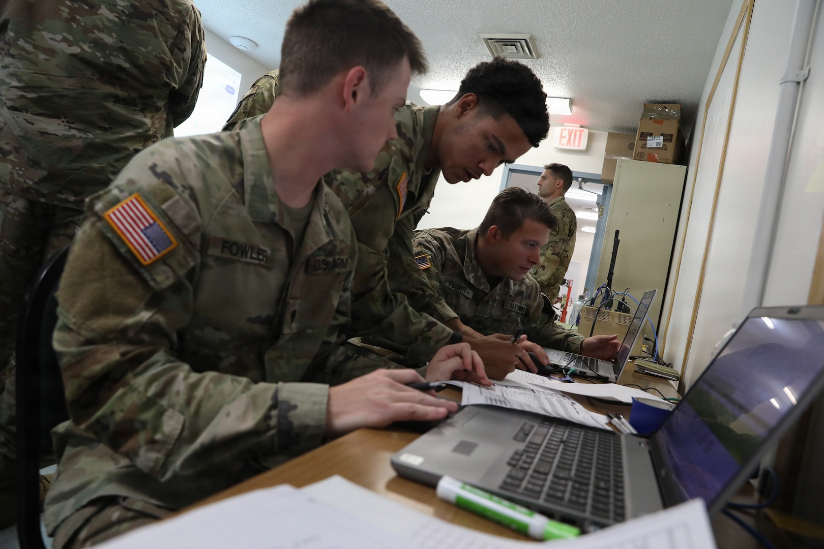 U.S Army Spc. Joseph Porter with C Company, 1st Battalion, 376th Aviation Regiment, Kentucky National Guard, confirms simulated mission data with fellow flight operations Soldiers Sgt. Shawn Fluhr (right), Headquarters and Headquarters Company 751st Troop Command and Spc. Christian Fowler (left), C Company, 1st Battalion, 376th Aviation Regiment, during Patriot 26 at Volk Field Combat Readiness Training Center, or CRTC, Wisconsin, Aug. 25, 2026.