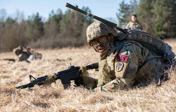 U.S. Army Pfc. Anthony Concepcion, assigned to Dental Health Command Europe, reacts to contact while completing an Expert Field Medical Badge lane during Medical Readiness Command, Europe’s 2025 Best Leader Competition at Grafenwoehr Training Area, Bavaria, Germany, March 18, 2025. (U.S. Army photo by Pfc. Brent Lee)