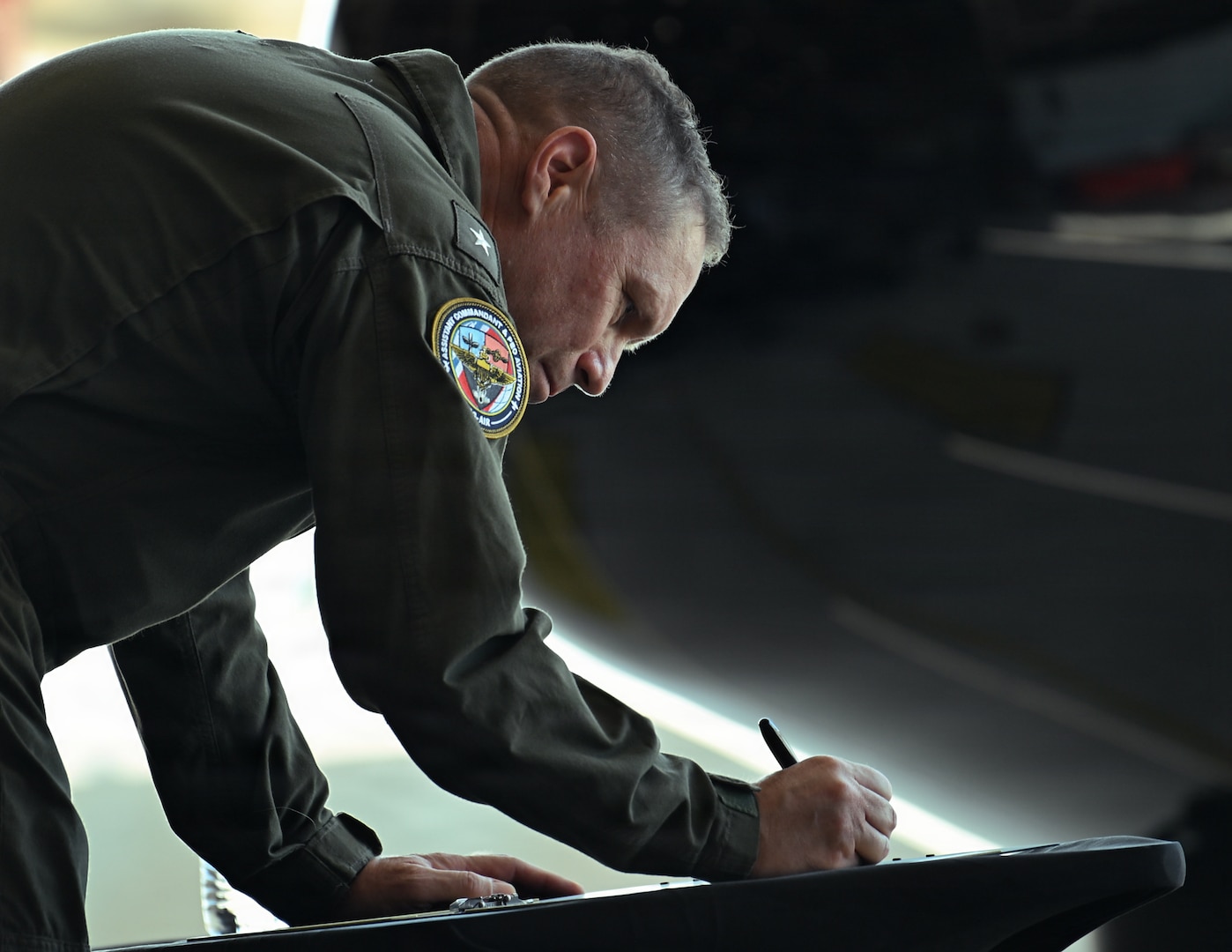 U.S. Coast Guard Rear Adm. Tad Wilson, assistant commandant for Aviation (CG-AIR), signs an aircraft panel during a ceremony at the air station in McClellan Park, California, Sept. 10, 2026. The Coast Guard commemorated the delivery of the first HC 130J Super Hercules aircraft to Air Station Sacramento during the ceremony. (U.S. Coast Guard photo by Petty Officer 3rd Class Kenneth Wiese)