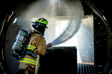 Airman 1st Class Xavier Zaragoza, a 23rd Civil Engineer Squadron firefighter, operates a fire hose during live-fire training at Moody Air Force Base, Ga., Aug. 20, 2026. The training enhances structural fire response capabilities and ensures rapid readiness for emergency response teams across the installation. (U.S. Air Force photo by Airman 1st Class Bre Lewis)