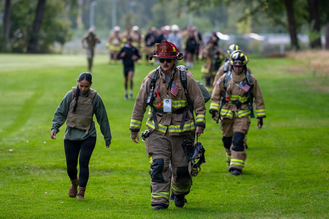 86th Civil Engineer Squadron firefighters and other personnel participate in the 9/11 memorial march.