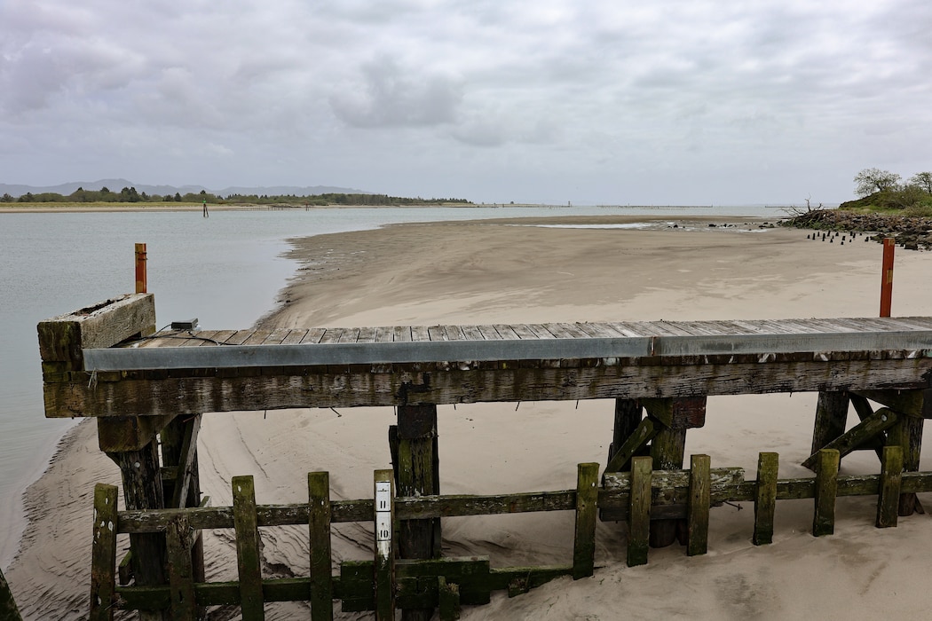 A shambled wooden pier looms over the coastline.