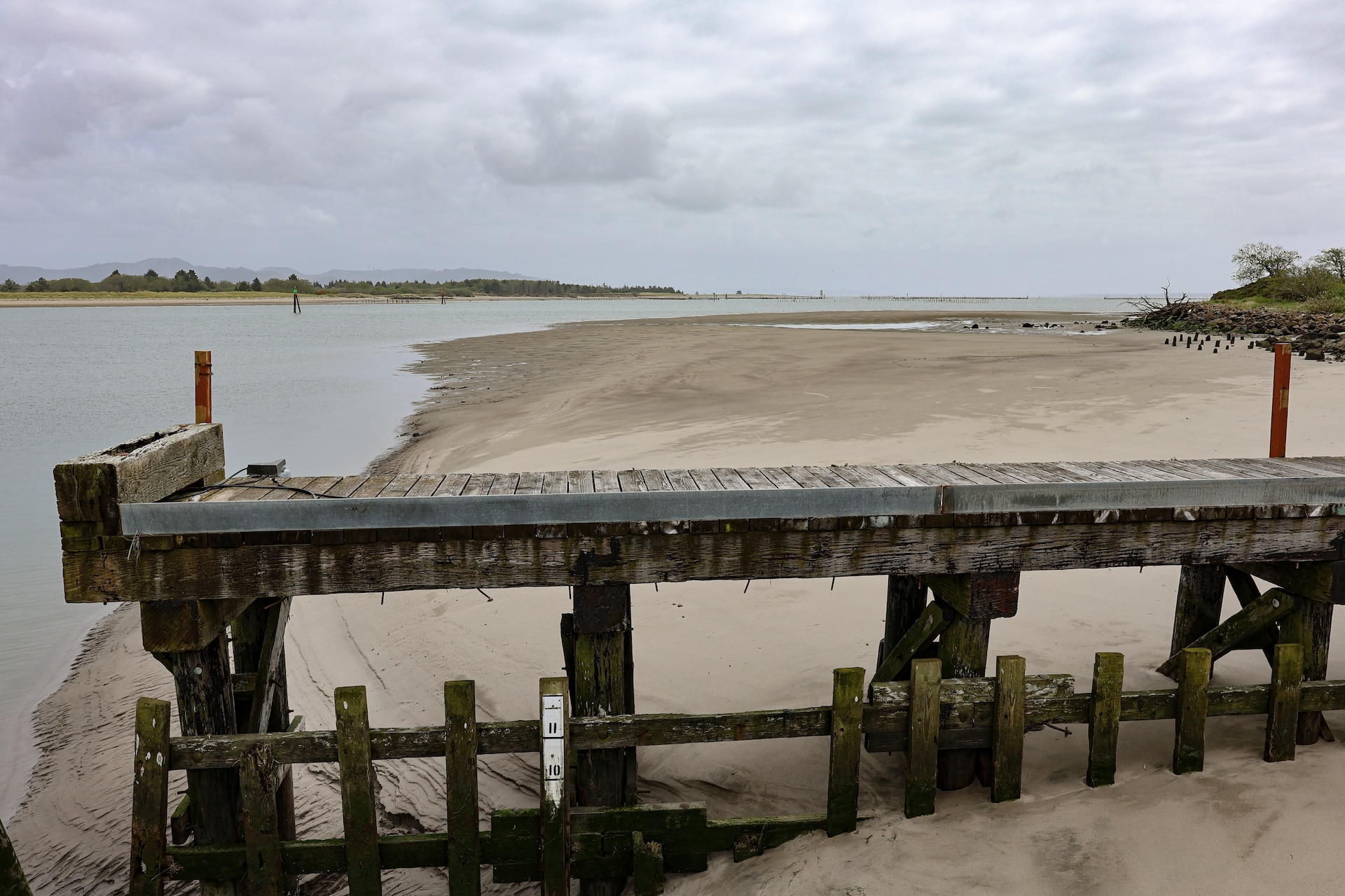 A shambled wooden pier looms over the coastline.