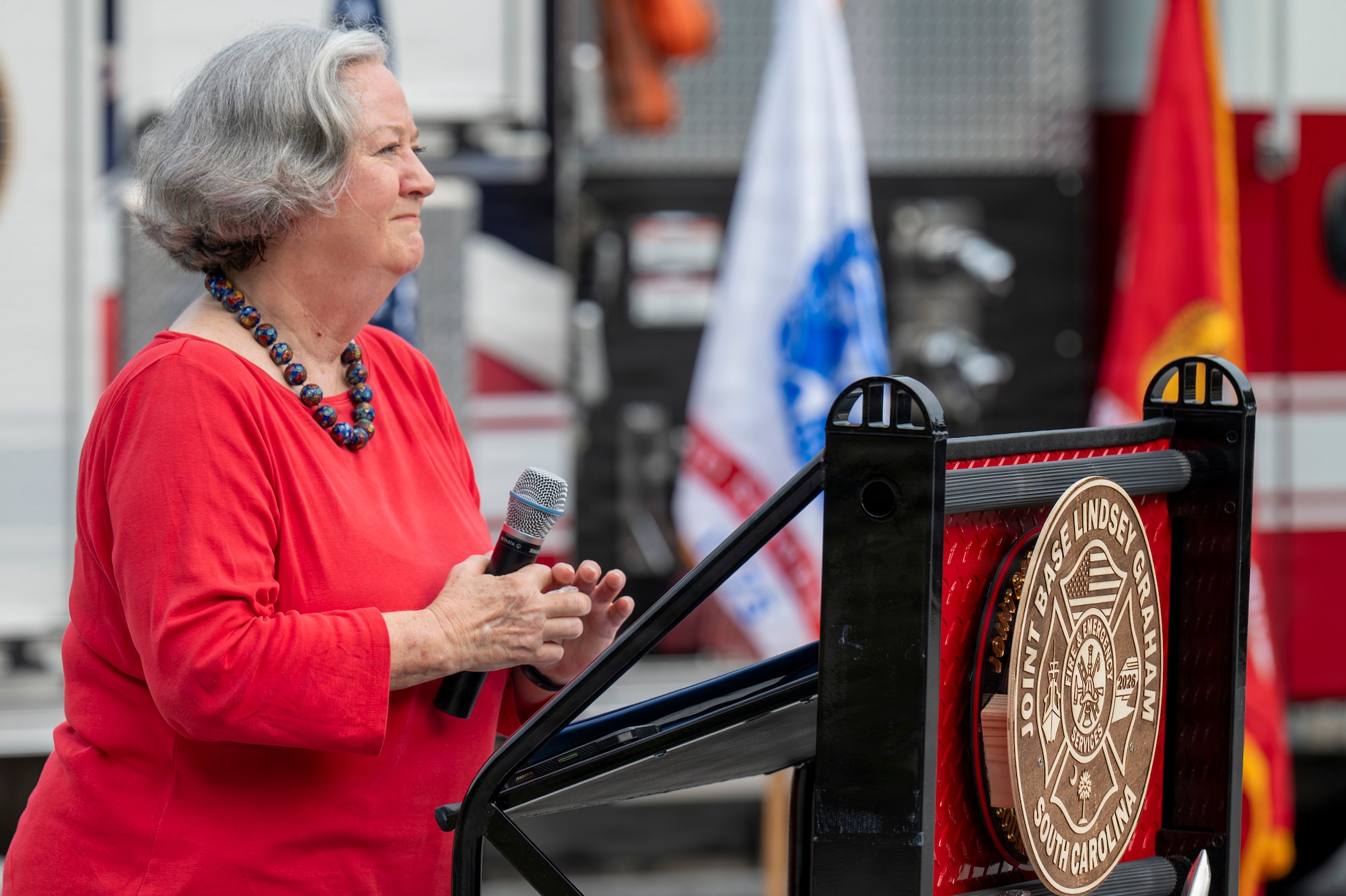A photo of a woman delivering a speech outside during a 09/11 Remembrance Ceremony