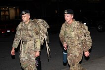 A photo of service members participating in a ruck march.