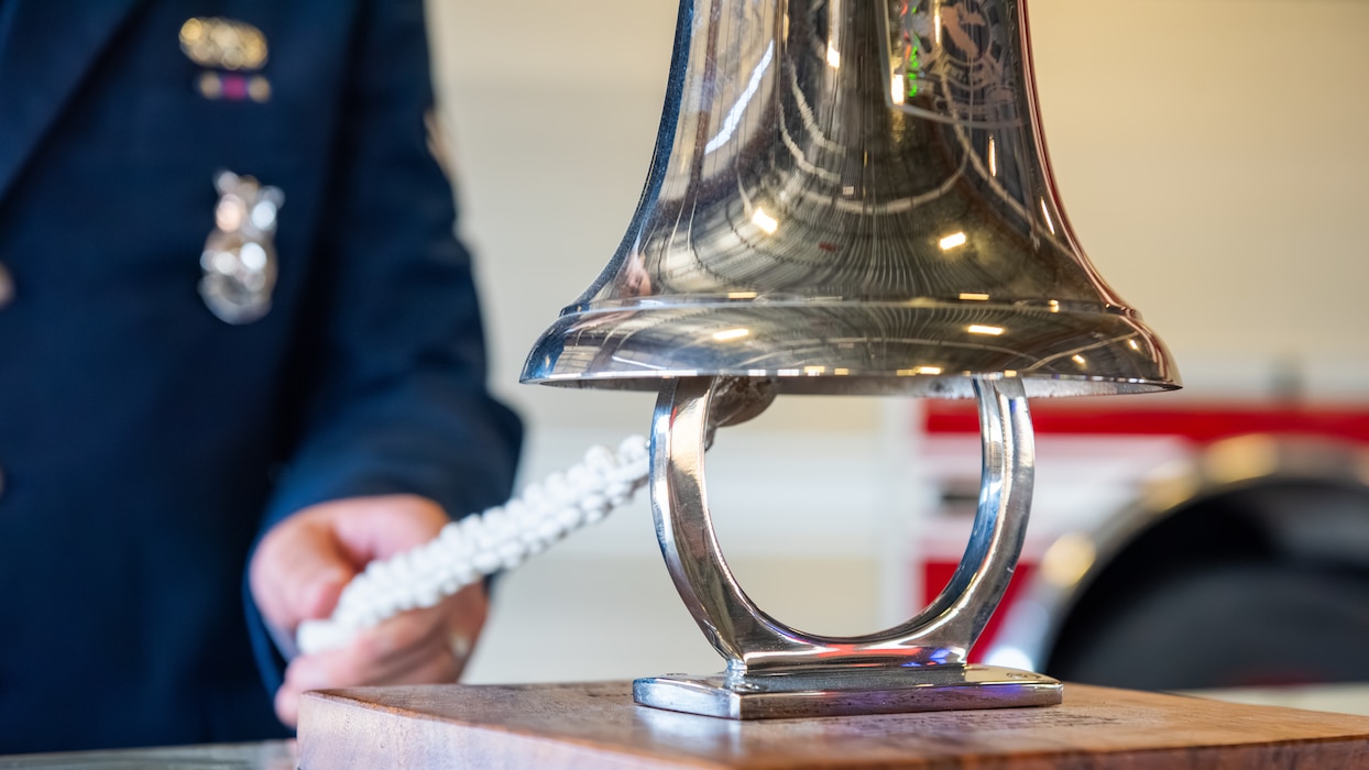 Close-up view of a ceremonial bell and white rope