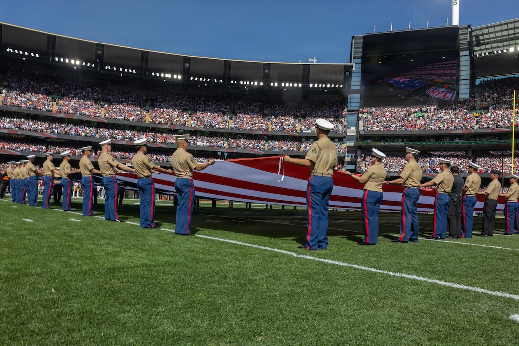 U.S. Marines with Marine Rotational Force – Darwin 26 present the American flag on the field during the opening ceremony of the first National Football League game played in Australia at the Melbourne Cricket Ground in Melbourne, Sept. 11, 2026.