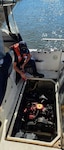 U.S. Coast Guard Petty Officer 2nd Class Alec Dunn, a boatswains mate assigned to Coast Guard Station Grand Haven, extinguishes a fire aboard a vessel in Lake Michigan Sept. 11, 2026. Dunn utilized a pump and fire extinguisher while standing fire watch as the boat crew towed the vessel back to shore where the passengers were returned to safety. (U.S. Coast Guard photo by Petty Officer 2nd Class Scott Caylor)