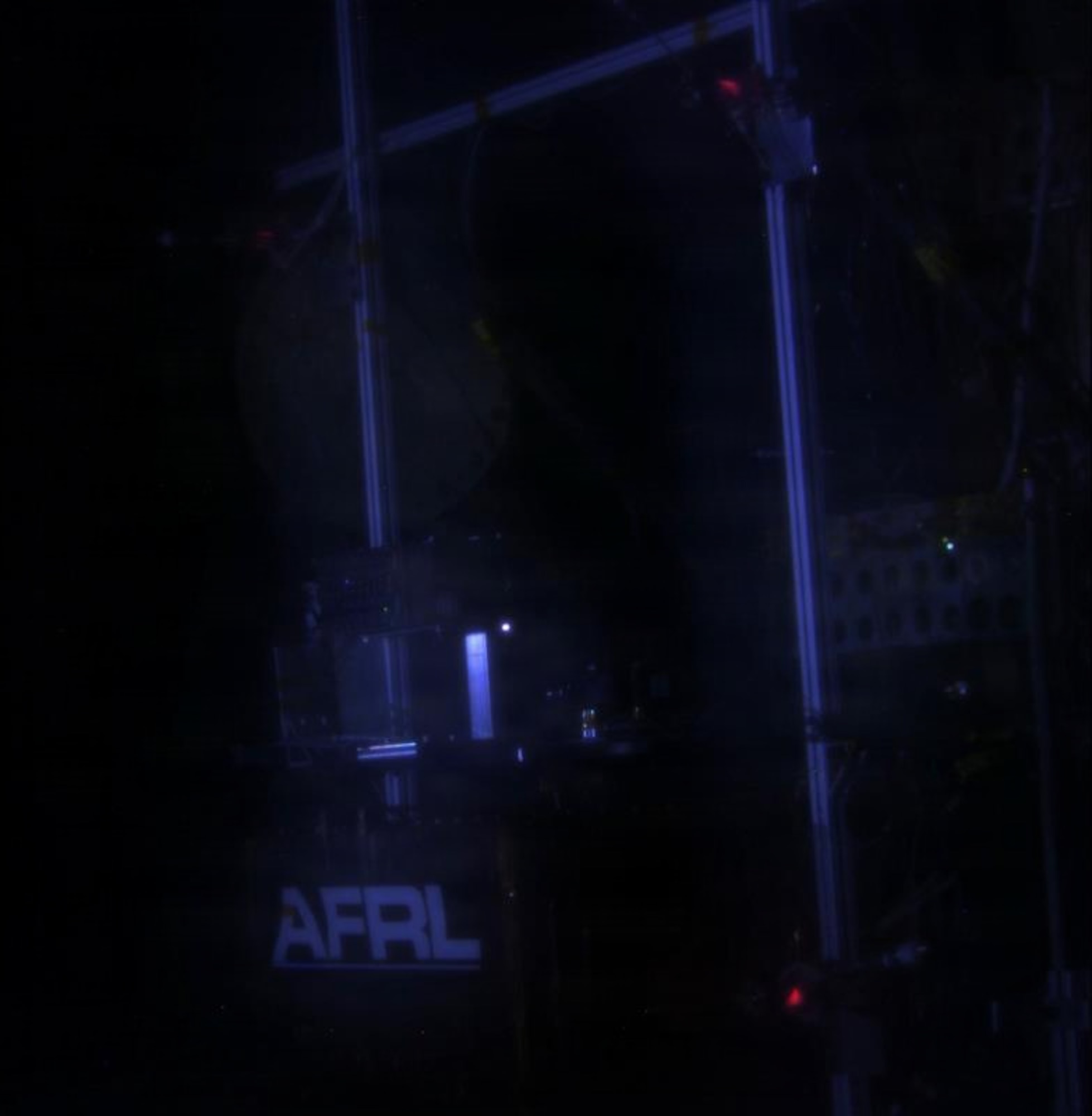 Snapshot of short-pulse live-fire testing of three monopropellant Advanced Spacecraft Energetic Non-Toxic (ASCENT) chemical thrusters (see red glow) for Modular Multimode Propulsion (MMP)