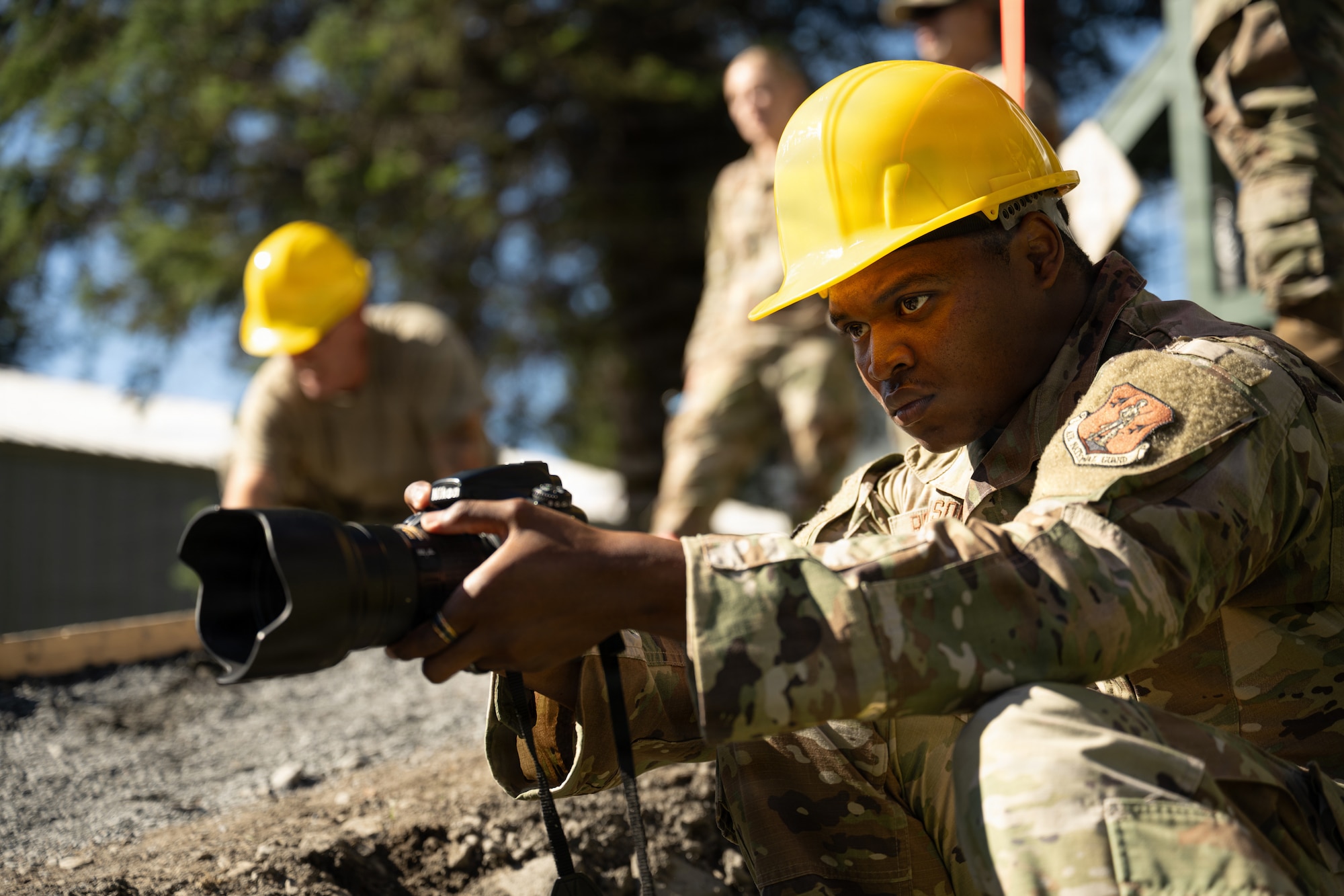 U.S. Air Force Senior Airman Elijah Robinson, 163d Attack Wing public affairs, California Air National Guard, documents civil engineer operations during a deployment for training (DFT) at Seward Military Resort in Seward, Alaska, Aug. 20, 2026. Thirty-nine Airmen across seven Air Force Specialty Codes participated in the fifth and final rotation of civil engineer units from across the country, conducting trenching, metal wrapping, electrical work, concrete placement and roofing across four structures. The DFT allowed Airmen to upgrade the Morale, Welfare and Recreation facility while completing training requirements that prepare them to perform their duties in overseas and deployed environments. Robinson used video, photography and written content to document and communicate civil engineer contributions to the project. (U.S. Air National Guard photo by Tech. Sgt. Pagan)