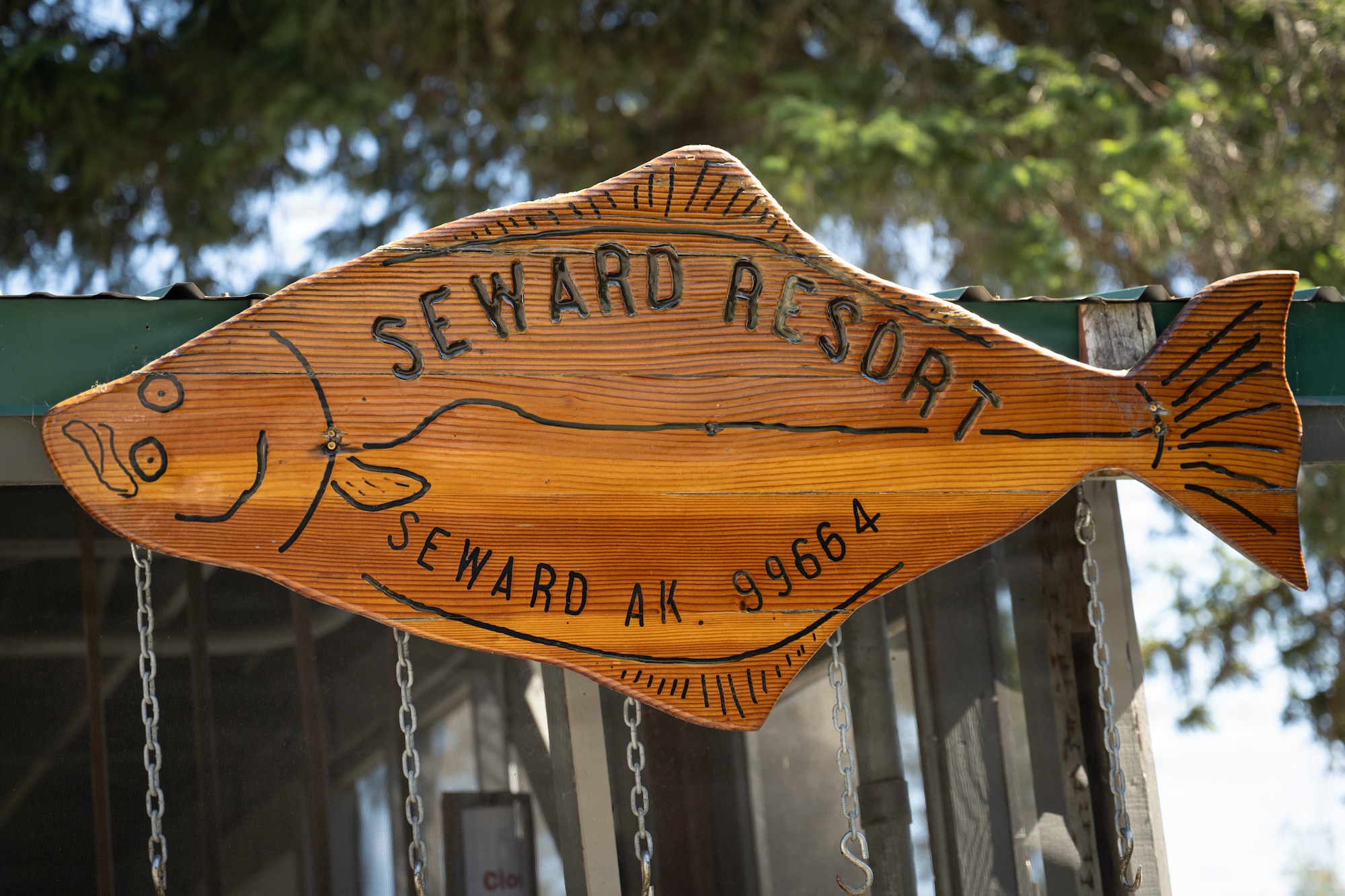 A wooden fish sign marks the Fish House at Seward Military Resort in Seward, Alaska, Aug. 20, 2026.. U.S. Airmen assigned to the 163d Civil Engineer Squadron, California Air National Guard, performed upgrade projects during a deployment for training (DFT) at Seward Military Resort in Seward, Alaska, Aug. 10-24, 2026. Thirty-nine Airmen across seven Air Force Specialty Codes participated in the fifth and final rotation of Civil Engineer units from across the country, conducting trenching, metal wrapping, electrical work, concrete placement and roofing across four structures. The DFT allows Airmen to upgrade the Morale, Welfare and Recreation facility while completing training requirements that prepare them to perform their duties in overseas and deployed environments. (U.S. Air National Guard photo by Tech. Sgt. Pagan)