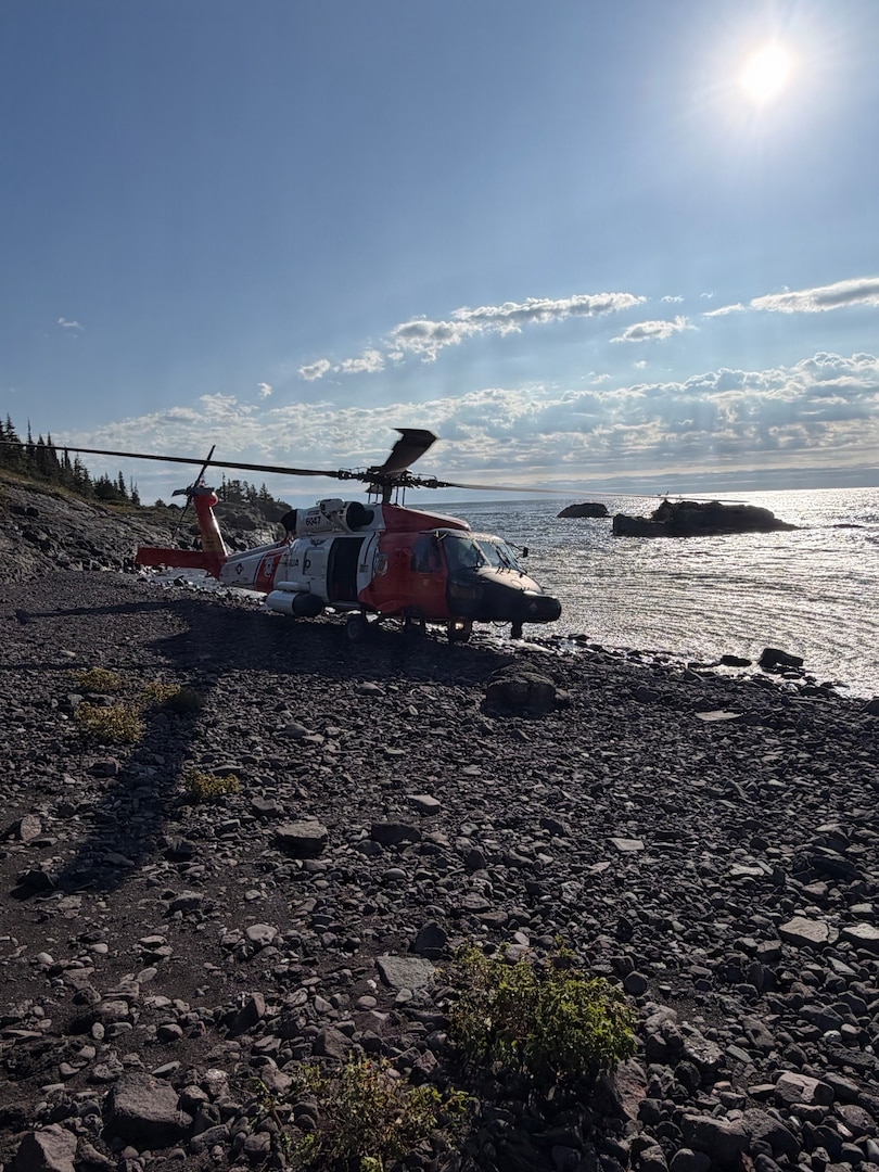 A U.S. Coast Guard Air Station Traverse City MH-60 Jayhawk helicopter sits on the shore of Isle Royale, Michigan, Sept. 11, 2026. The helicopter crew transported Michigan State Police troopers and K-9 units to the island to search for a missing hiker. (U.S. Coast Guard photo, courtesy Air Station Traverse City)