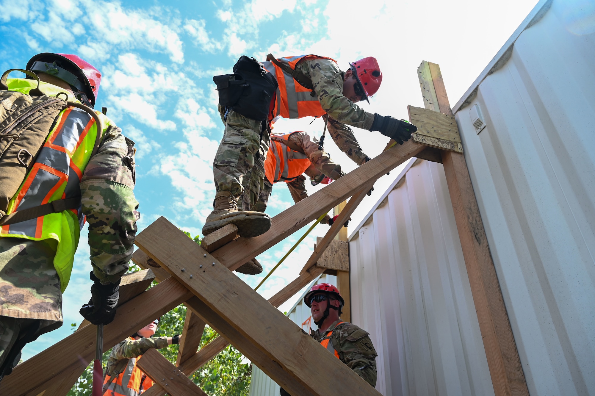 A Nebraska Army National Guard Soldier secures boarding while constructing an alternate entrance to a simulated disaster site during a disaster response exercise in Yutan, Nebraska, Sept. 2, 2026. Creating alternate access points allows response teams to enter compromised structures when traditional entrances may be blocked or unsafe, helping personnel reach simulated casualties for extraction and treatment.