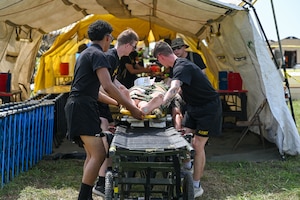 Nebraska Army National Guard Soldiers process a simulated casualty through a decontamination point during a disaster response exercise in Yutan, Nebraska, Sept. 2, 2026. Decontamination personnel work to remove potentially hazardous contaminants before casualties move to the next stage of assessment and medical treatment, helping protect patients, responders and treatment areas from further exposure.