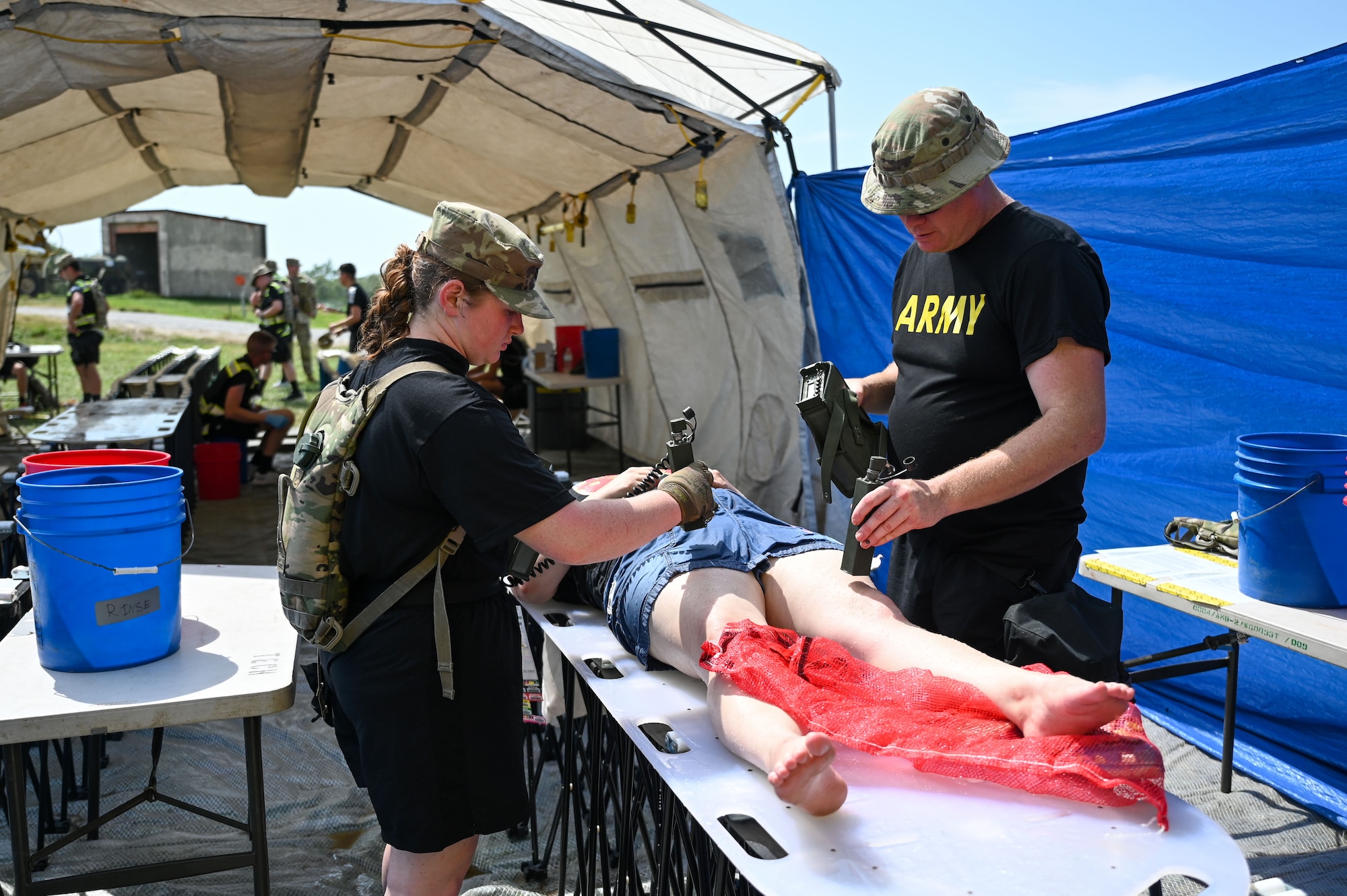 Two Nebraska Army National Guard Soldiers use a PDR-77 radiation detector to examine a simulated casualty during a disaster response exercise at the Atlas Readiness Center near Yutan, Nebraska, Sept. 2, 2026. The detector is used to identify residual radiation or contamination and determine whether a casualty requires additional decontamination before proceeding to medical assessment and treatment.