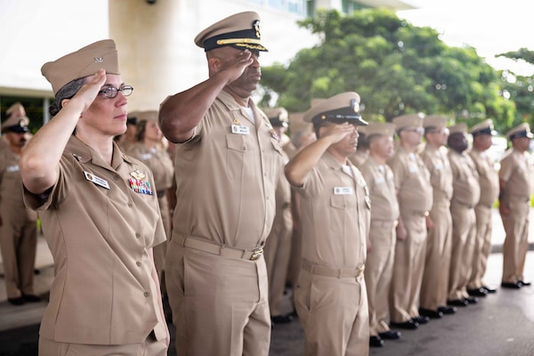 Capt. Richard Gilliard Jr., center-left, commanding officer, Navy Medicine Readiness and Training Command (NMRTC) Okinawa; Capt. Robyn Treadwell, left, executive officer, NMRTC Okinawa; and Senior Chief Hospital Corpsman William Imperial, center-right, standing in for the command master chief, NMRTC Okinawa, salute during a morning colors ceremony on Camp Foster, Okinawa, Japan, Sept. 11, 2026. The ceremony commemorated the 25th anniversary of the 9/11 attacks. (U.S. Navy photo by Mass Communication Specialist 1st Class Simon Pike)
