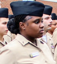 Hospital Apprentice Keyona Whyte stands at attention during the 25th anniversary 9/11 commemoration at Navy Medicine Readiness and Training Command (NMRTC) Patuxent River, Sept. 11, 2026. As one of the junior Hospital Corpsmen who recited the minute-by-minute timeline of the 2001 attacks, Whyte participated in passing down the day's solemn history and lessons to fellow Sailors.