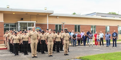 Active-duty military personnel and civilian staff gather on the grounds of Navy Medicine Readiness and Training Command (NMRTC) Patuxent River during a special 25th anniversary Sept. 11 morning colors ceremony, Sept. 11, 2026. The command-wide observance commemorated the 2001 terrorist attacks through a recount of the day's major event milestones, a moment of silence, and the lowering of the National Ensign to half-staff