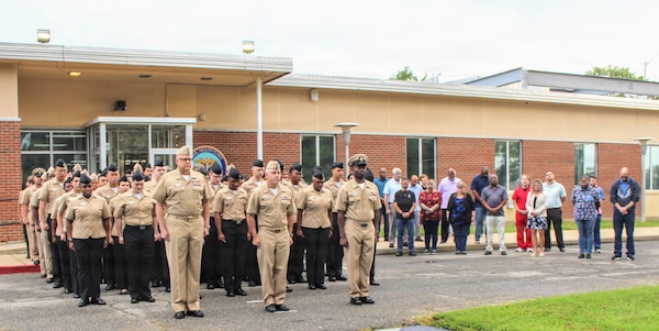 Active-duty military personnel and civilian staff gather on the grounds of Navy Medicine Readiness and Training Command (NMRTC) Patuxent River during a special 25th anniversary Sept. 11 morning colors ceremony, Sept. 11, 2026. The command-wide observance commemorated the 2001 terrorist attacks through a recount of the day's major event milestones, a moment of silence, and the lowering of the National Ensign to half-staff