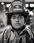 A man un firefighter gear poses for a photo.