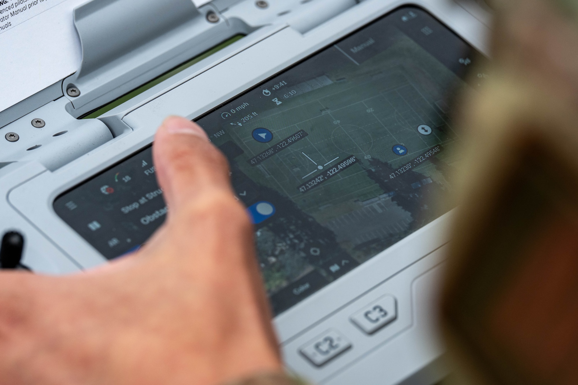 A hand manipulates a drone remote screen.