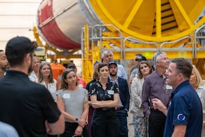 a group of people listen to a person speak