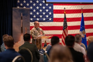a person speaks at a podium to a crowd