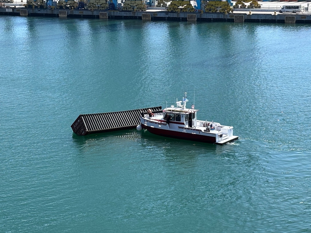 A Los Angeles Fire Department smallboat rides next to one of three 40-ft containers that fell off a ship during cargo operations in the Port of Los Angeles, September 14, 2026.