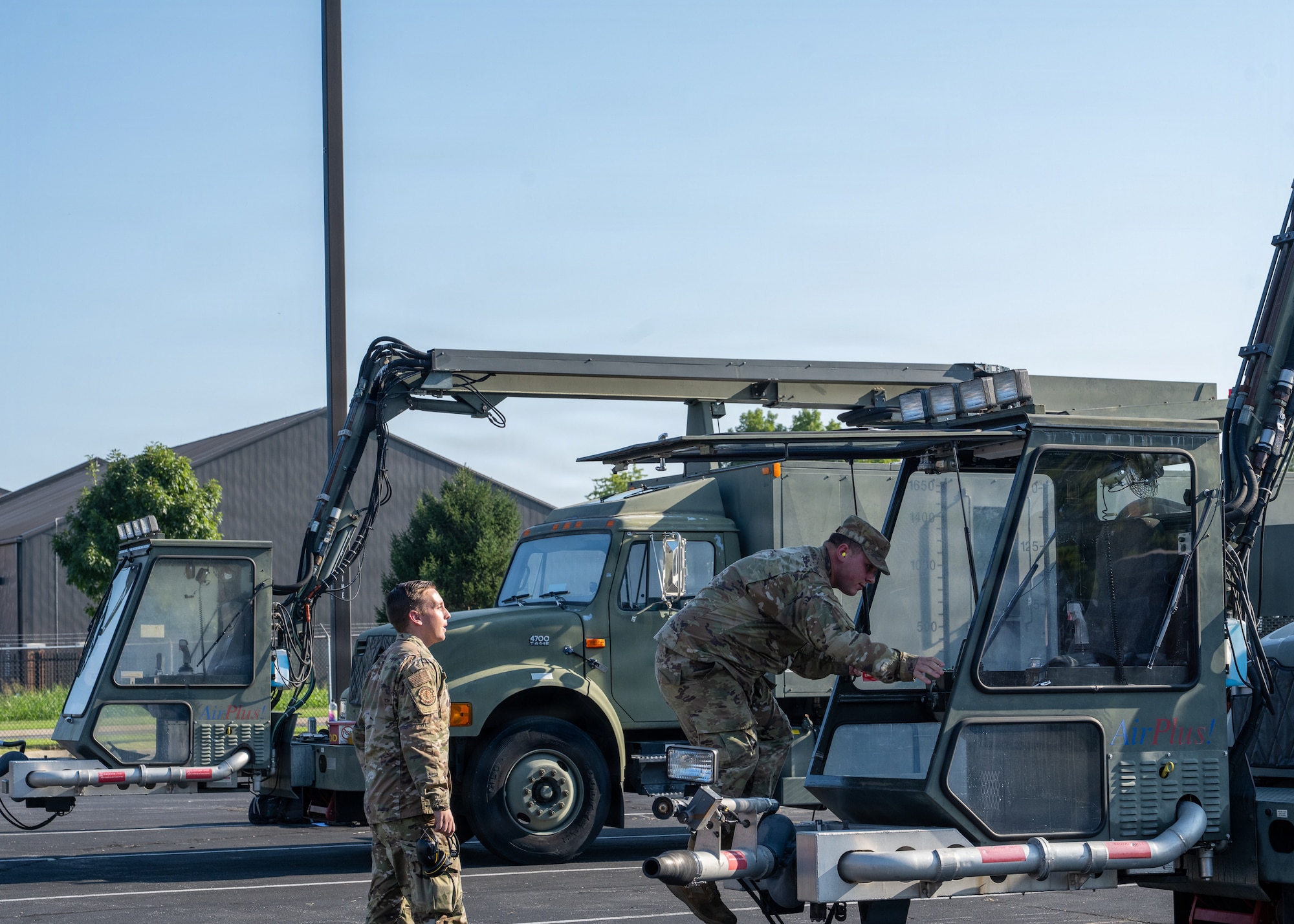 An Airman enters the cab of a deicer.
