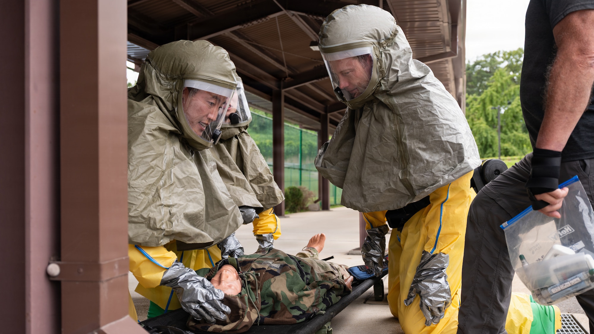 Medical personnel assess a training mannequin.