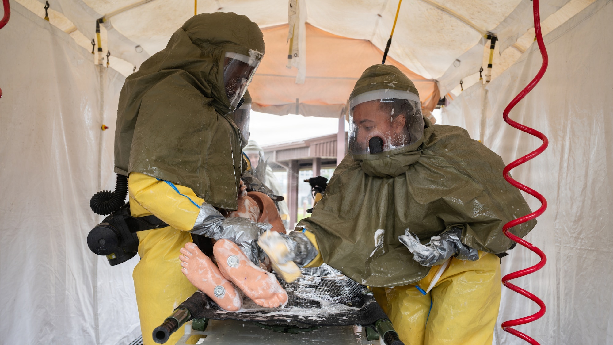 Medical personnel scrub a decontaminated mannequin.