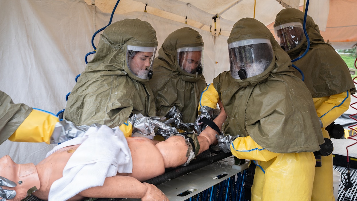 Medical personnel scrub a decontaminated mannequin.