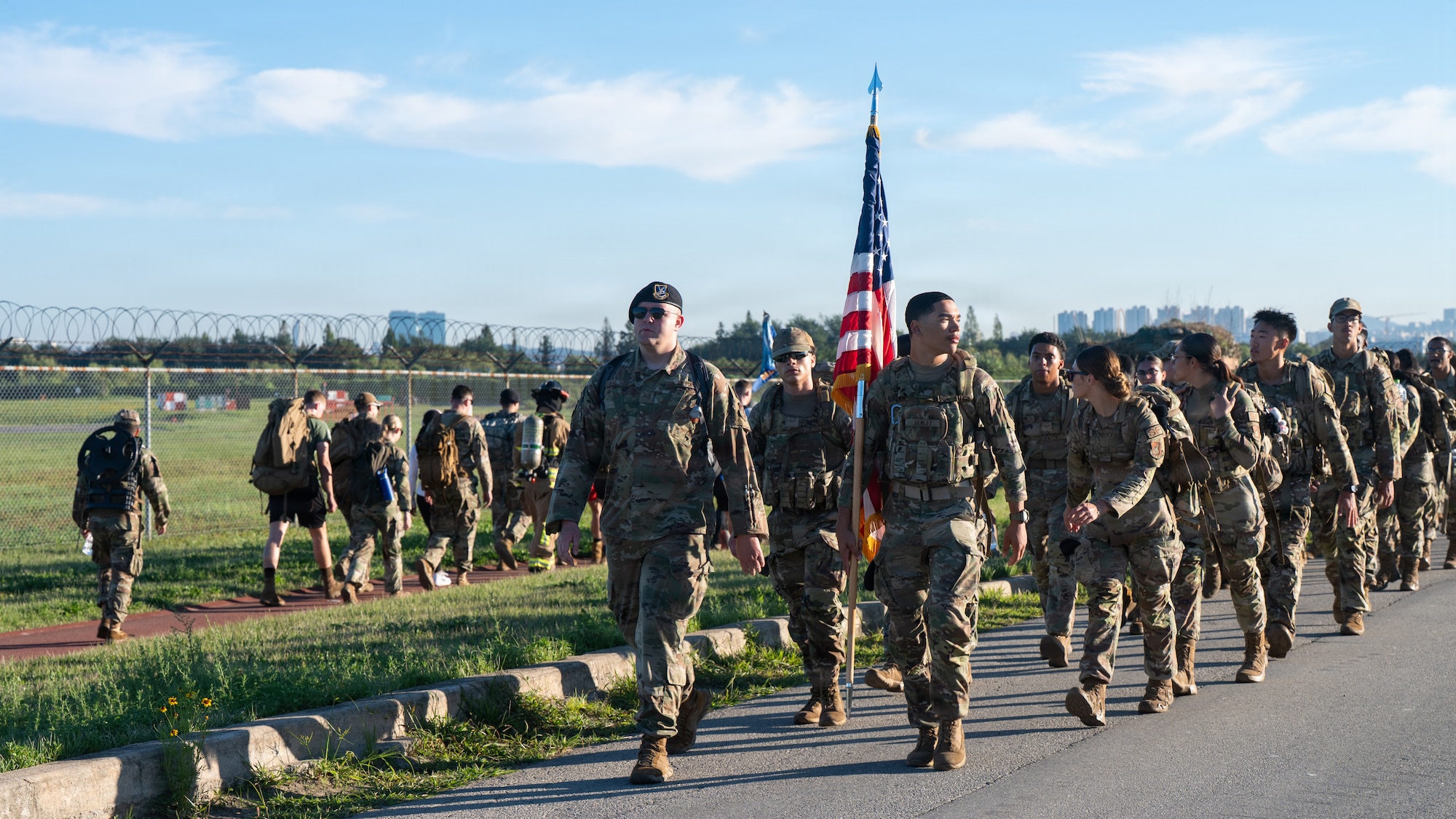 U.S. service members carry weighted gear during a ruck march at Osan Air Base, Republic of Korea, Sept. 11, 2026. The event brings service members together to remember the lives lost and honor those who demonstrated courage and selflessness in the aftermath of the 9/11 terrorist attacks. (U.S. Air Force photo by Senior Airman Jessica Mun)