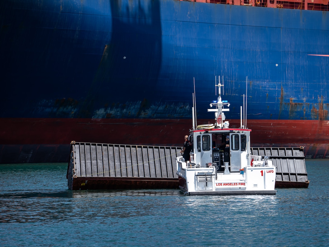 A Los Angeles Fire Department 40-foot small boat crew pushes a container to the pier at the Los Angeles Harbor, Sept. 14, 2026.