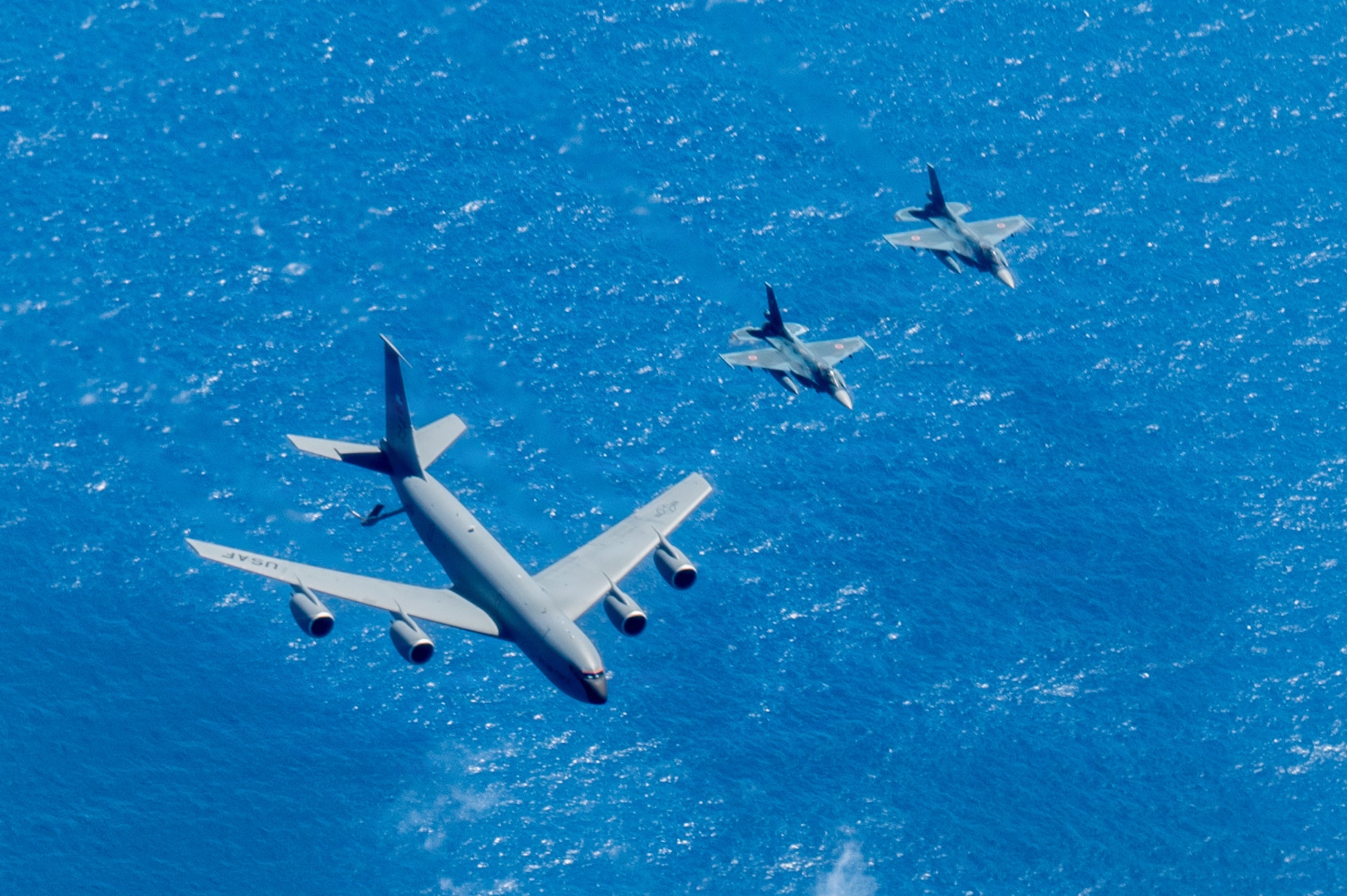 A U.S. Air Force KC-135 Stratotanker assigned to the 909th Air Refueling Squadron, and two Japan Air Self-Defense Force Mitsubishi F-2s assigned to the 8th Fighter Squadron, fly in formation during bilateral training over the Pacific Ocean, Sept. 2, 2026.