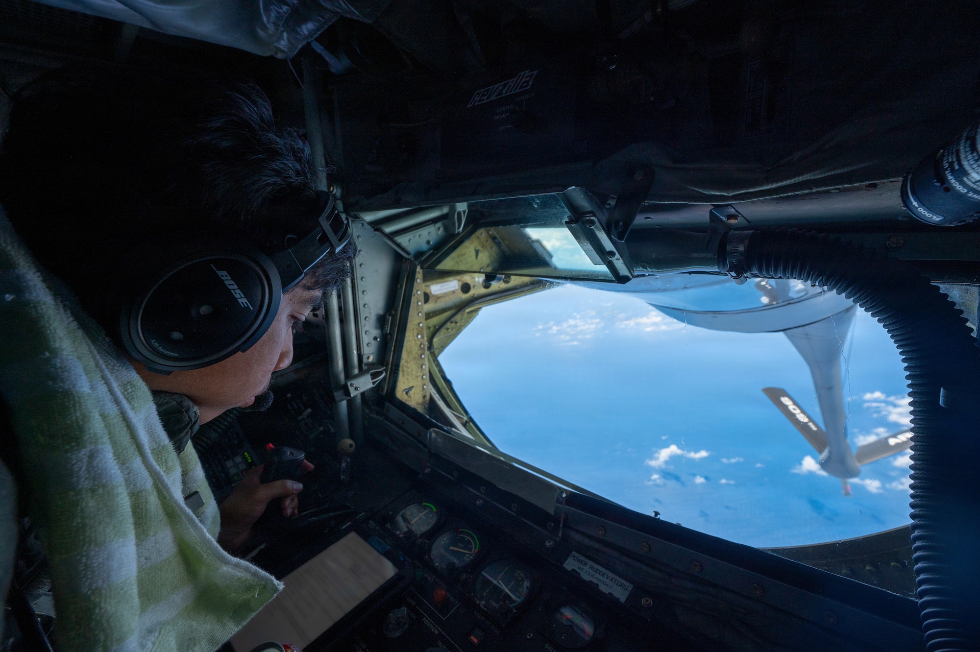 U.S. Air Force Senior Airman Landren Dela Cruz, 909th Air Refueling Squadron boom operator, conducts routine checks from the boom pod of a KC-135 Stratotanker over the Pacific Ocean, Sept. 2, 2026