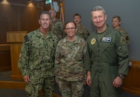 From right, Chairman of the Joint Chiefs of Staff Air Force Gen. Dan Caine, Tech. Sgt. Jessica Kassimer, 48th Operational Medical Readiness Squadron aerospace medicine flight chief, and Senior Enlisted Advisor to the Chairman SEAC David Isom, pose for a photo during a visit at RAF Lakenheath, England, Sept. 14, 2026.
