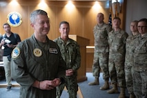 From left, Chairman of the Joint Chiefs of Staff Air Force Gen. Dan Caine and Senior Enlisted Advisor to the Chairman SEAC David Isom prepare to present coins to 48th Fighter Wing Airmen during a visit at RAF Lakenheath, England, Sept. 14, 2026.
