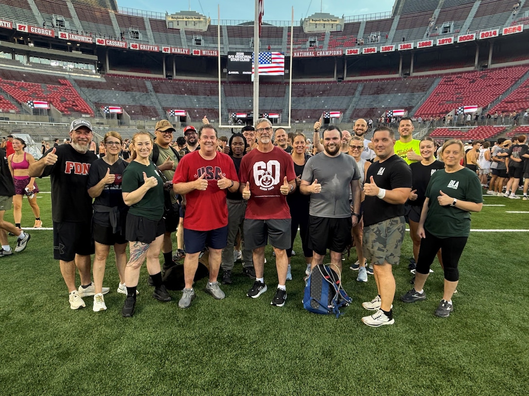 Group poses for photo on turf of football stadium