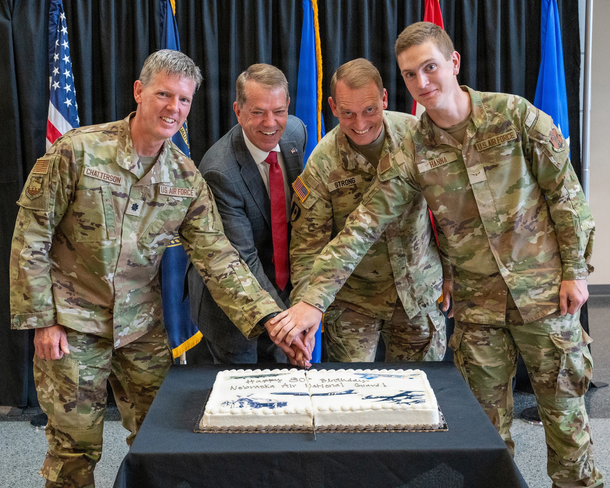 The Honorable Jim Pillen, Nebraska's governor, and the Adjutant General of the Nebraska National Guard, Maj. Gen. Craig Strong join Lt. Col. Michael Chatterson and Airman Joseph Hanna from the 155th Airlift Wing, in a cake-cutting ceremony at the Nebraska National Guard Joint Force Headquarters in Lincoln, Nebraska, September 13, 2026. Per Air Force tradition, Chatterson and Hanna were the most senior and most junior serviing Airmen at the event which commemorated the Nebraska Air National Guard's 80th anniversary. (U.S. Air National Guard photo by Tech. Sgt. Phil Cowen)