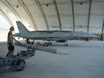 A U.S. Airman assigned to the Collaborative Combat Aircraft Experimental Operations Unit prepares to load an inert missile onto a YFQ-44A Fury aircraft at Creech Air Force Base, Nevada, July 20, 2026. The exercise integrated the semi-autonomous aircraft into simulated combat operations, focusing on rapidly deploying from dispersed locations. (U.S. Air Force photo by Senior Airman Renee Blundon)