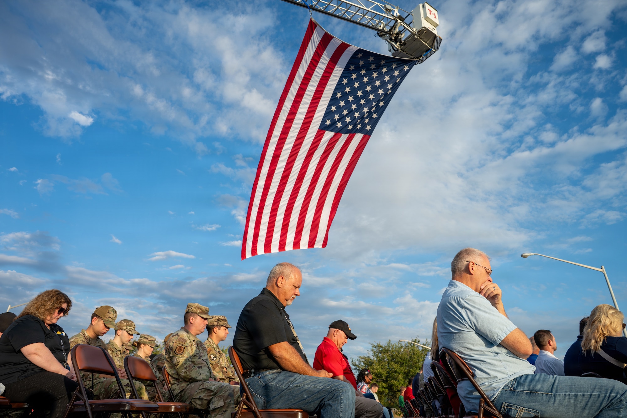 People bowing with U.S. flag over them