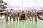 West Virginia Army National Guard members pose for a photos in front of a Jaguar statue in Peru.