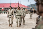 Peruvian Army and U.S. Army Generals salute and walk during an opening ceremony.