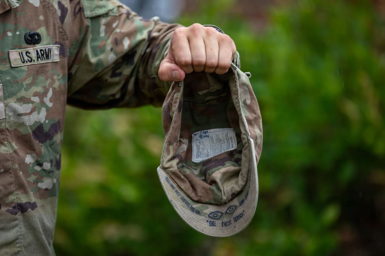 Pvt. Matthew Scaccia, an infantryman with New Hampshire National Guard C Company, 3rd Battalion, 172nd Infantry Regiment (Mountain), holds up his patrol cap to display the motto “BE NOT AFRAID” and tally marks for each day, 62 in all, completed at Ranger School.