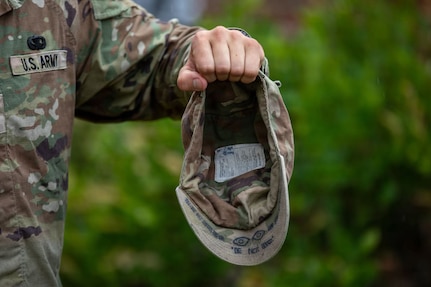 Pvt. Matthew Scaccia, an infantryman with New Hampshire National Guard C Company, 3rd Battalion, 172nd Infantry Regiment (Mountain), holds up his patrol cap to display the motto “BE NOT AFRAID” and tally marks for each day, 62 in all, completed at Ranger School.